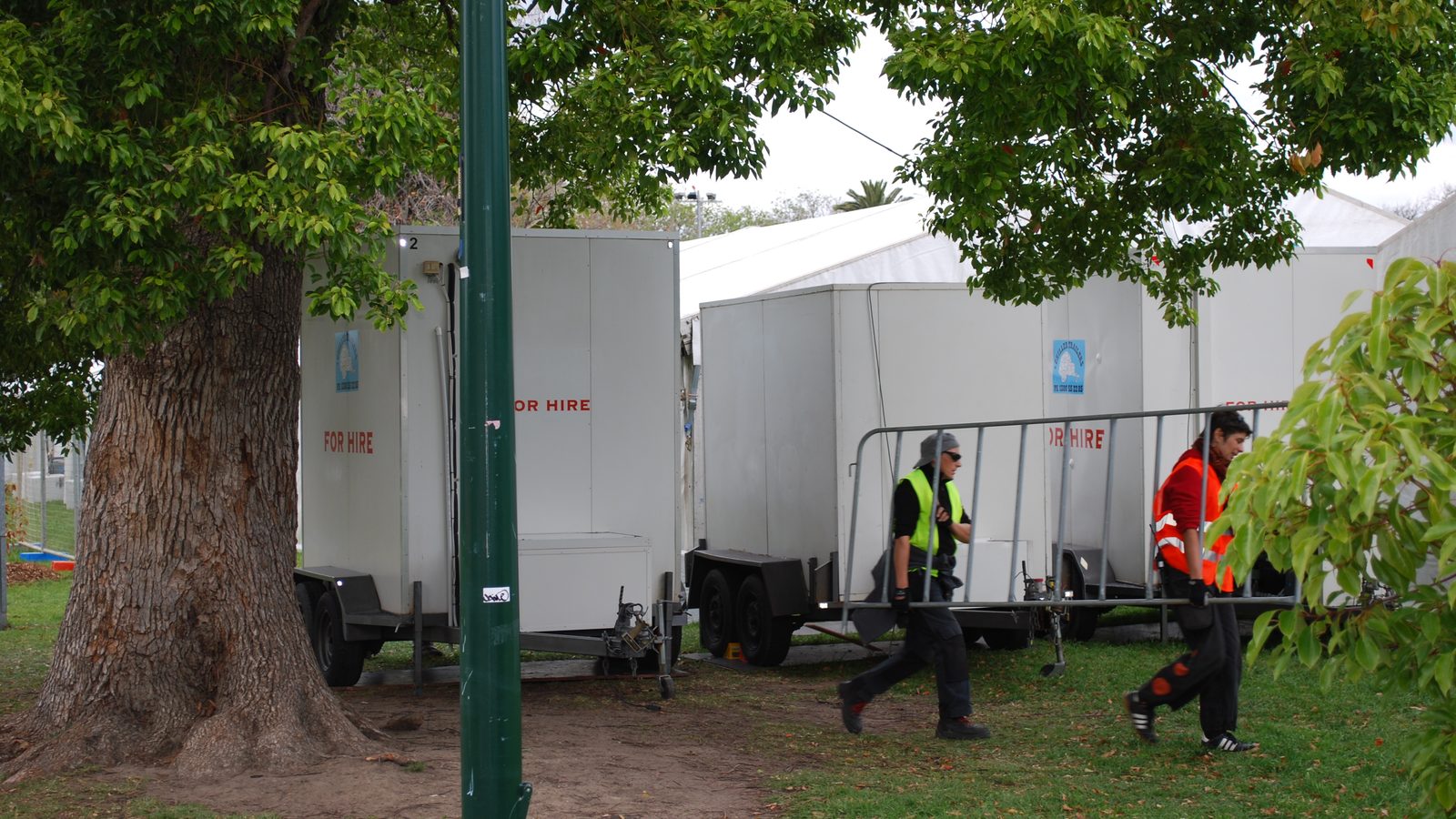 Cool room trailers on grass beside event marquees under trees